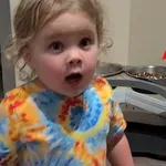 Majhna deklica se trudi dokazati staršem, da se ni dotikala pasje hrane