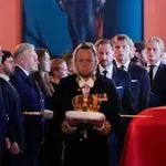 Posnetek nošenja kraljeve krste dviguje prah, ste videli, kdo stoji zadaj?