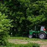 Traktor zgrmel pod cesto, voznik huje poškodovan